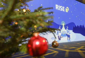 A picture of the screen with a Christmas tree and a Christmas tree bauble in the foreground (out of focus)